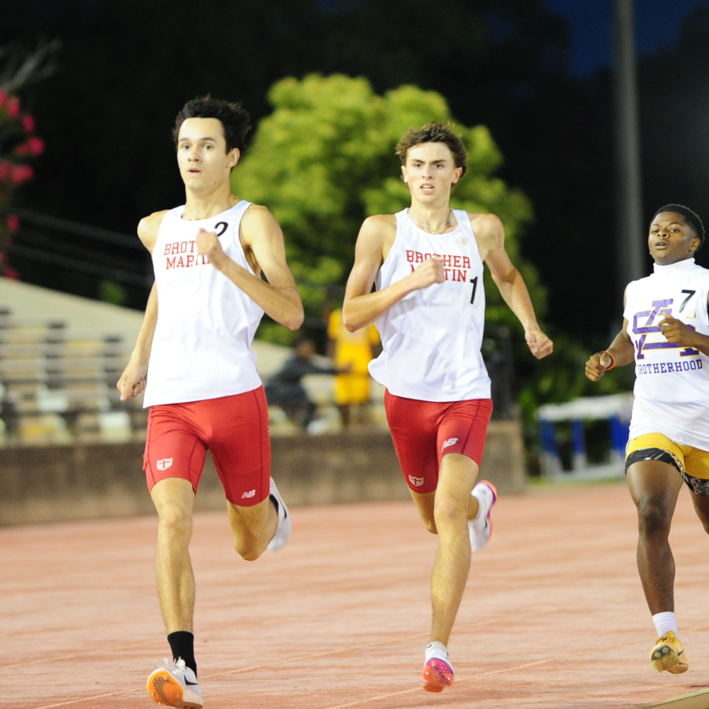 Ian Acosta escorts teammate Brayden Bulloch to the finish of the 800-meter run at the District 9-5A championship meet. The 1-2 finish in this event added 18 points to Brother Martin's second place totals.