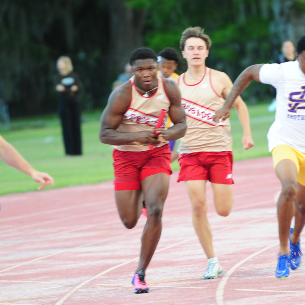 Junior anchorman  Easton Royal takes a handoff of the baton from Devin Kensel and streaks to the finish of the 4x100-meter relay. The Crusader foursome  won the event in the time of 41.40.
Royal contributed wins in the relay, 100-meter dash and placed second in the 200.