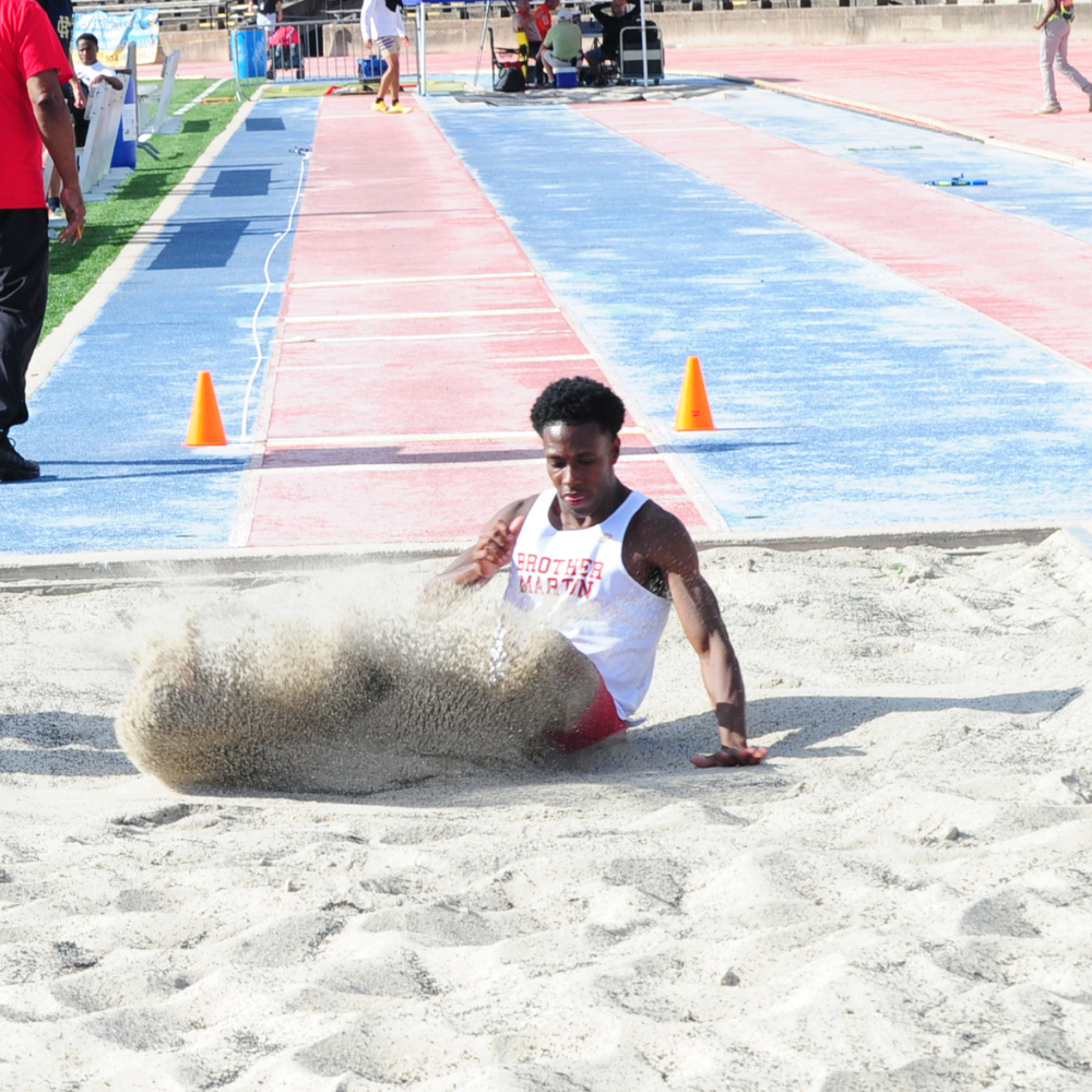 Sand flies as Evan Moller sticks a 21-5 1/2 landing in the district long jump event, an event in which he placed third against the district's top competition. Moller also scored points for the Crusaders in the 4x100-meter relay and 200-meter dash.